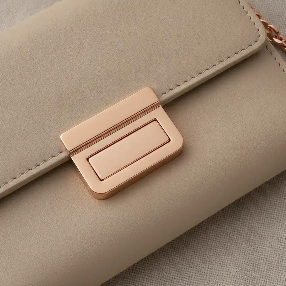 Detail shot of gleaming rose gold hardware on a cream beige wallet